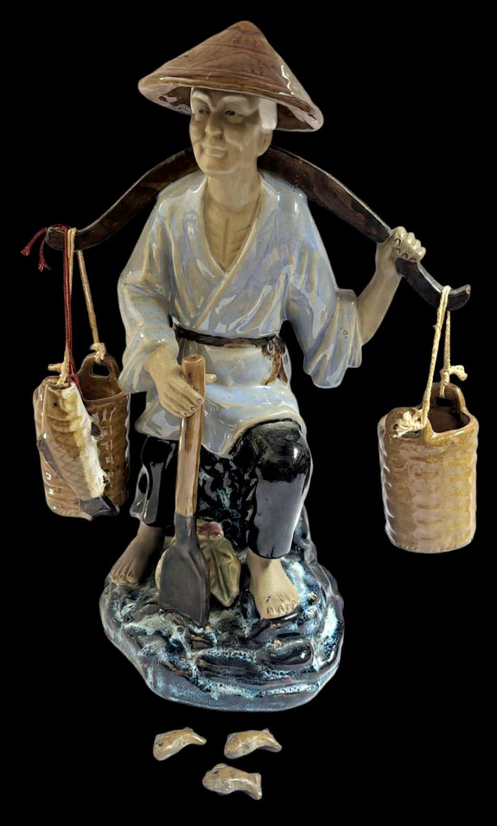 Belíssima escultura produzida em cerâmica de origem oriental, representando pescador, maior comprimento 30 cm, muito decorativa, com bicado na calda do peixe.