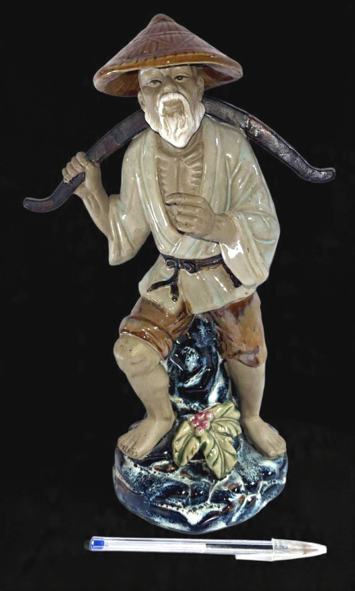 Belíssima escultura produzida em cerâmica de origem oriental, representando pescador, maior comprimento 32,5cm, muito decorativa, sem a vara de pescar os cestos.