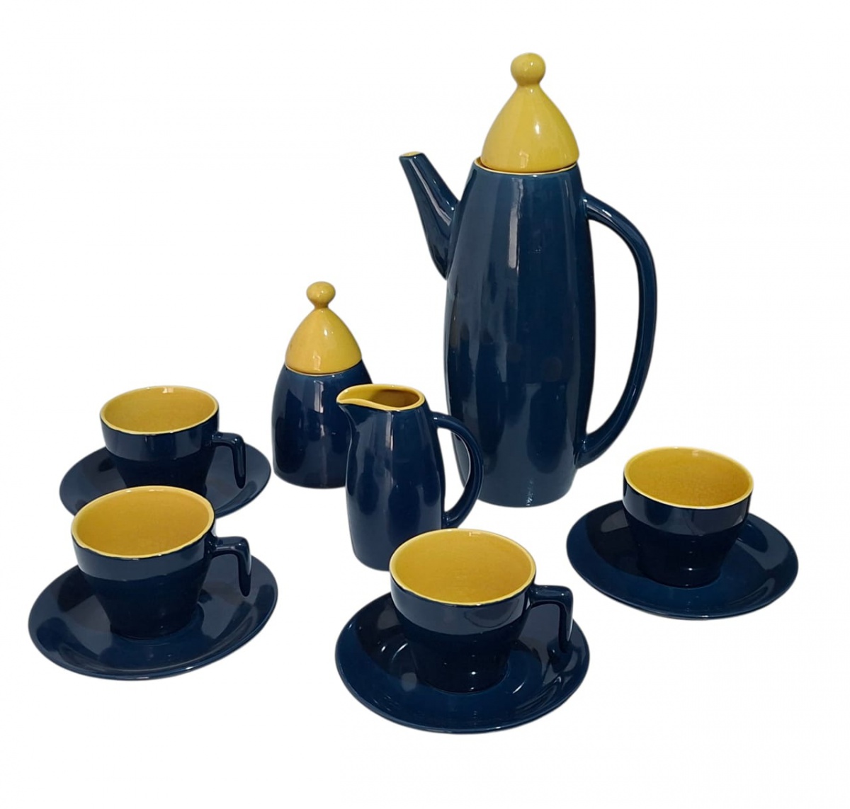 Moderno conjunto de café, modelo reto kitsch, com quatro xícaras com pires, um açucareiro, uma leiteira (ou cremeira) e um bule bastante alto (31cm), contando ao todo com 11 peças. Em ótimo estado.