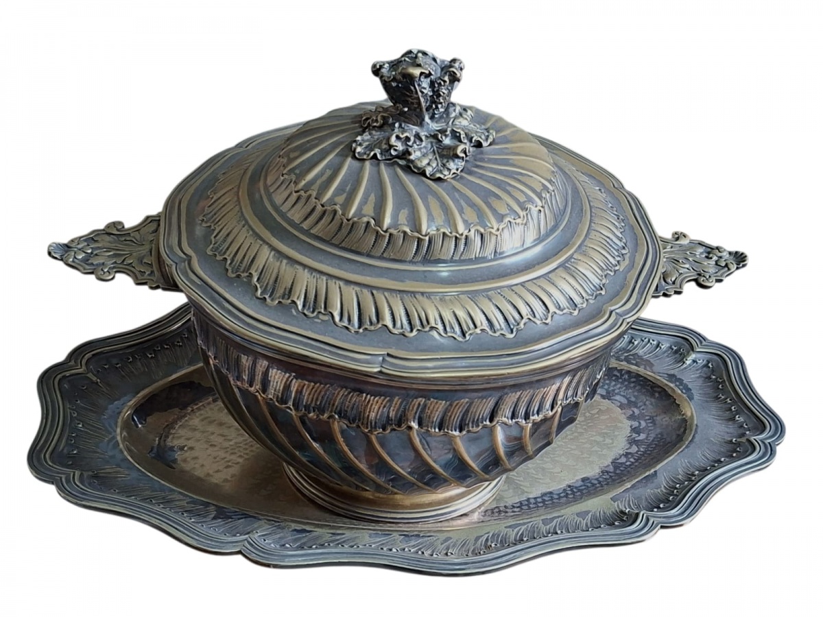 Belíssima sopeira com travessa, feita de metal espessurado e necessitando de um novo banho de prata, porém riquíssima em detalhes: destaque para o pegador, em forma de folhas de verduras, muito detalhado. 48x25.