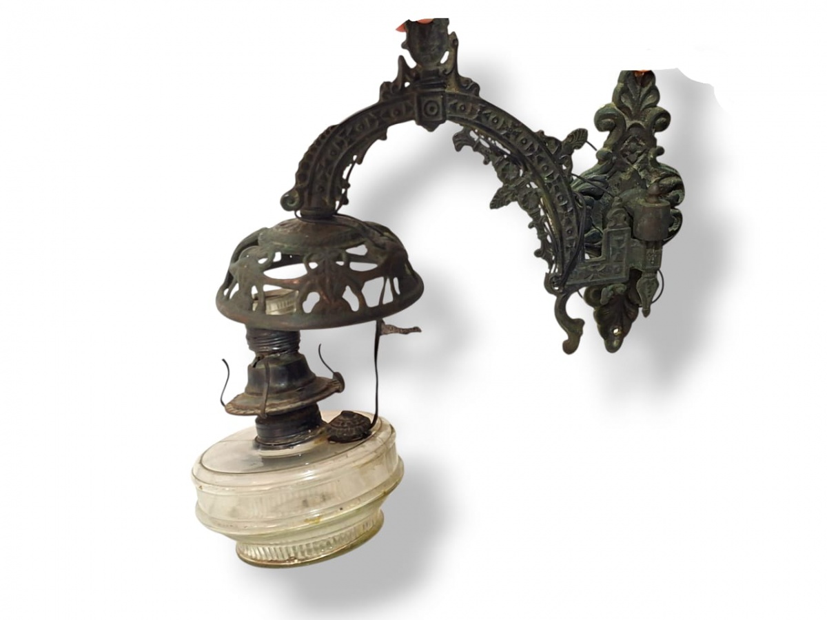 Antiga luminária de parede ou arandela em metal fundido bastante decorado, ideal para portas de entrada residenciais. Conta com manga de vidro para proteção da lâmpada. 40cm.