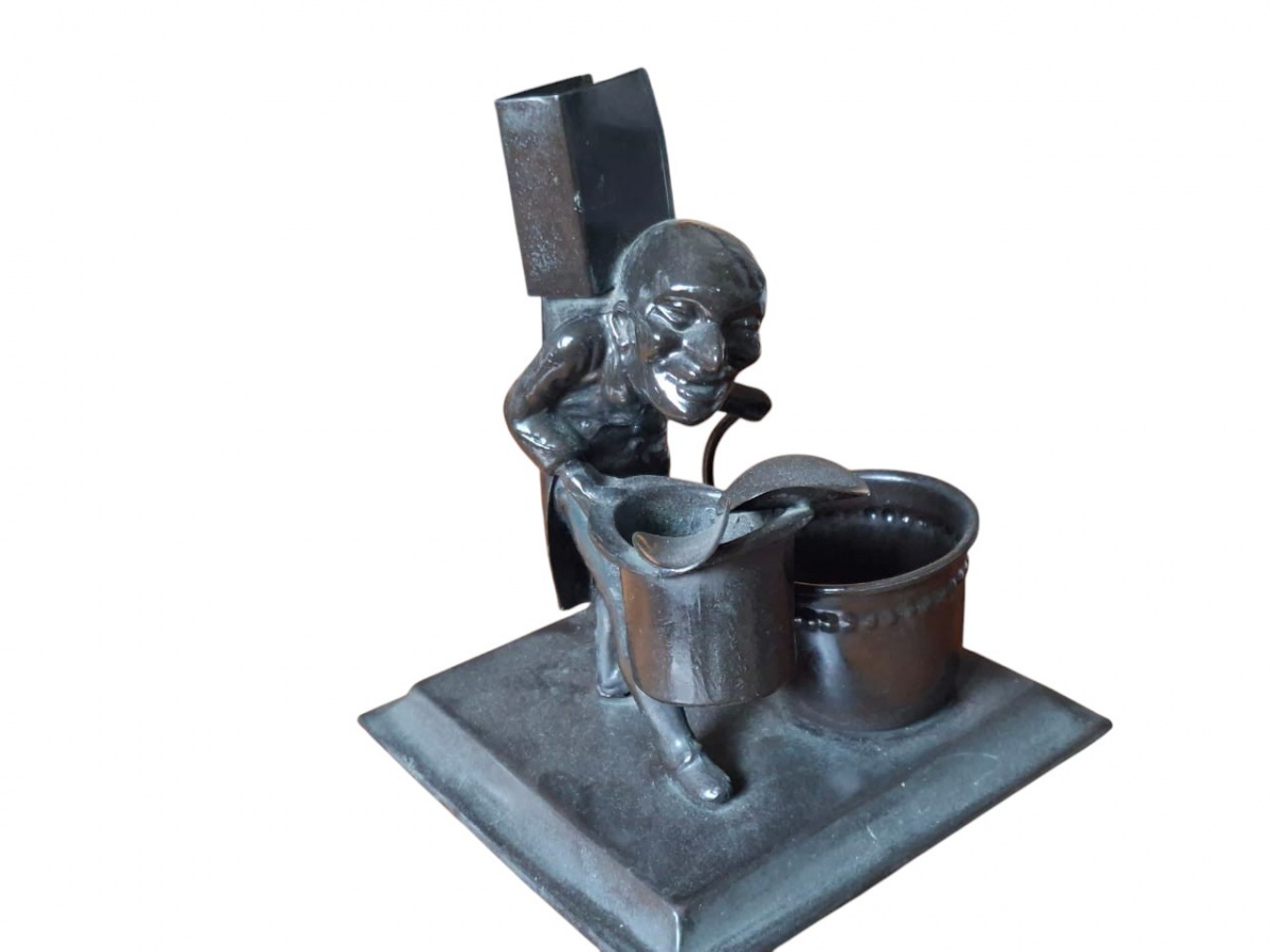 Antigo porta-lápis em metal, retratando caricatura. 19cm.