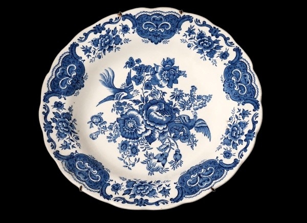 RIDGWAYS  Belo prato decorativo em porcelana inglesa Ridgways, pertencente à linha Windsor, marcado por decoração azul em formatos florais e animais. 21cm.