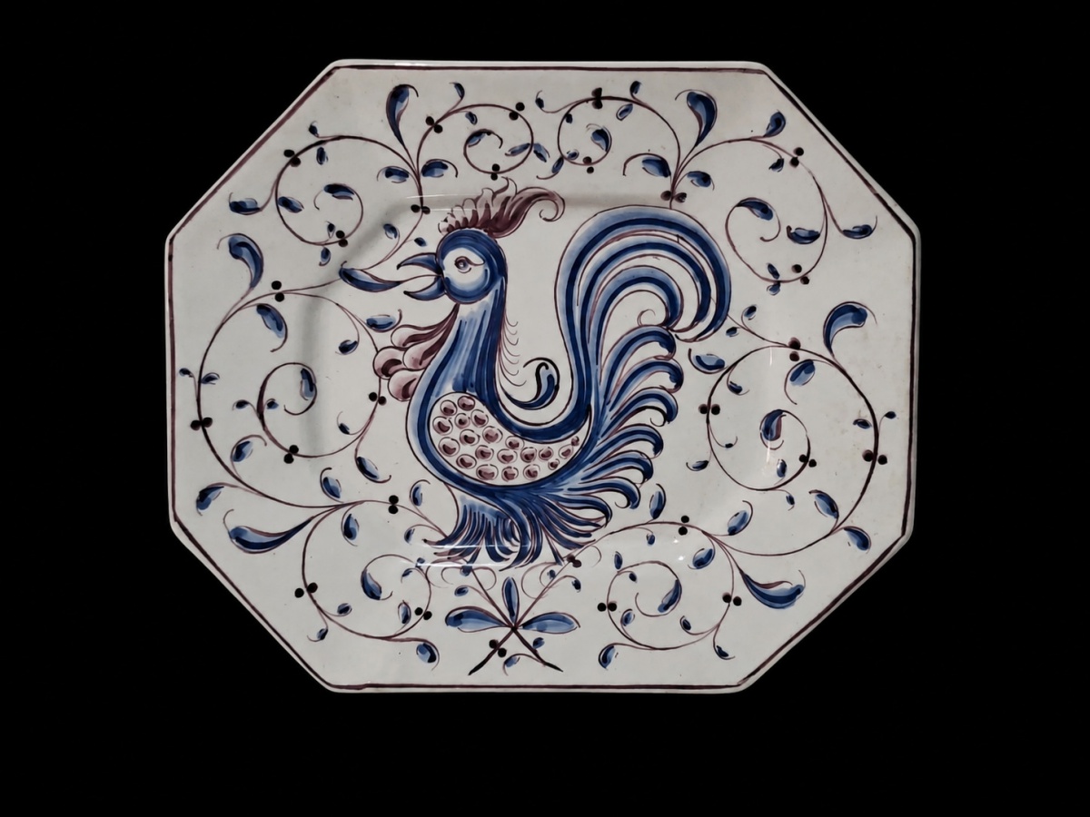 Magnífica travessa em porcelana portuguesa, toda pintada à mão, assinada e datada (Silva, Águeda, 1985). A retratação central é de um típico galo português. 30cm.