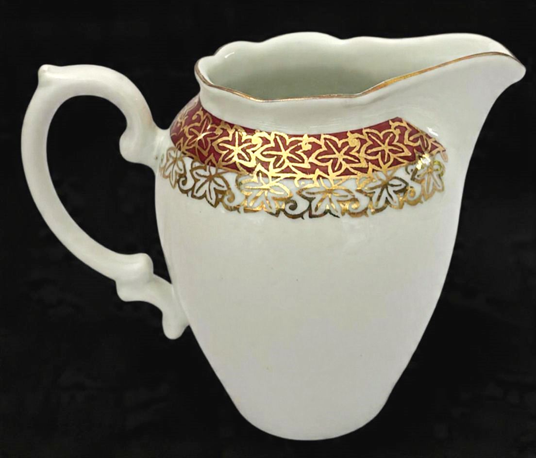 RENNER-Bela cremeira produzido em porcelana, com ornamentação de faixa vinho, com detalhes estilizado no formato de flor em filetação de ouro, maior comprimento: 9cm altura