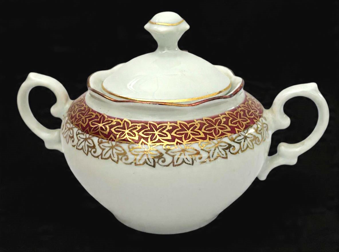 RENNER-Belo açucareiro produzido  em porcelana, com ornamentação de faixa vinho, com detalhes estilizado no formato de flor em filetação de ouro, maior comprimento:6 cm altura.