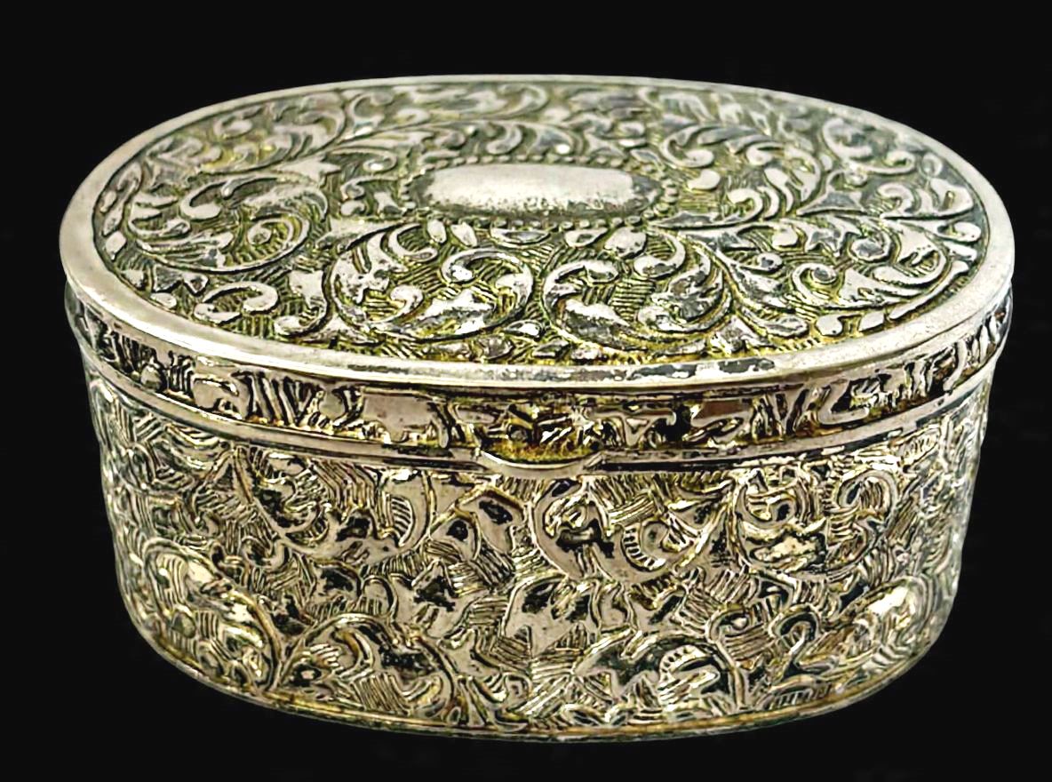 Mimoso porta joias antigo produzido em metal, ornamentado com arabescos e volutas, no formato oval, maior comprimento:9cm.