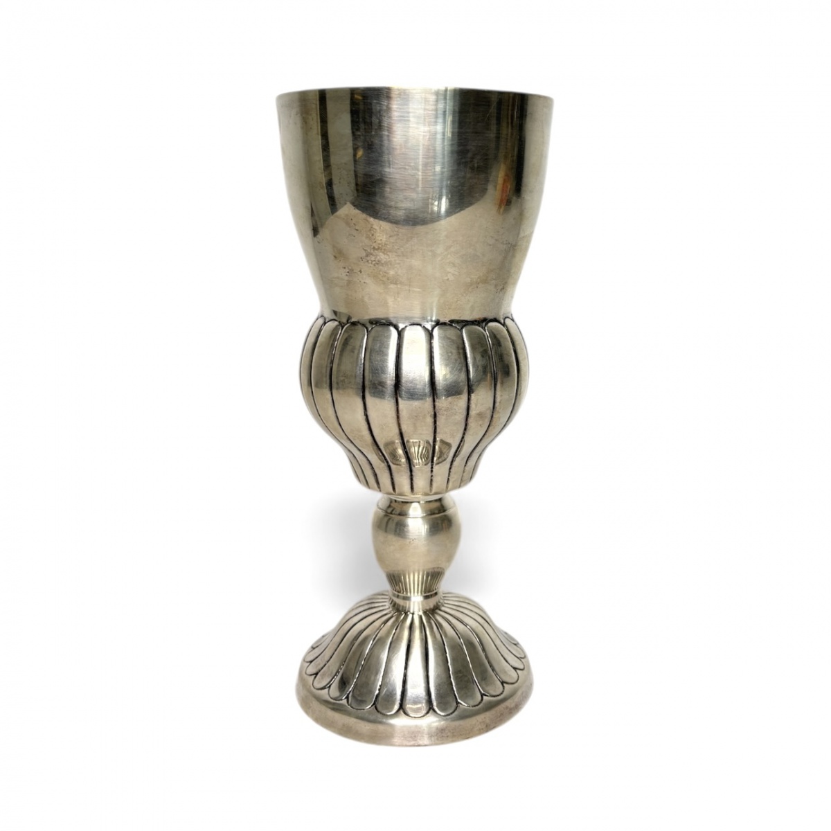 Cálice litúrgico antigo em metal espessurado a prata, corpo almofadado com sulcos verticais e base modelada em gomos. Peça de presença, elegante e com pátina natural do tempo. Ideal para composições decorativas ou ...