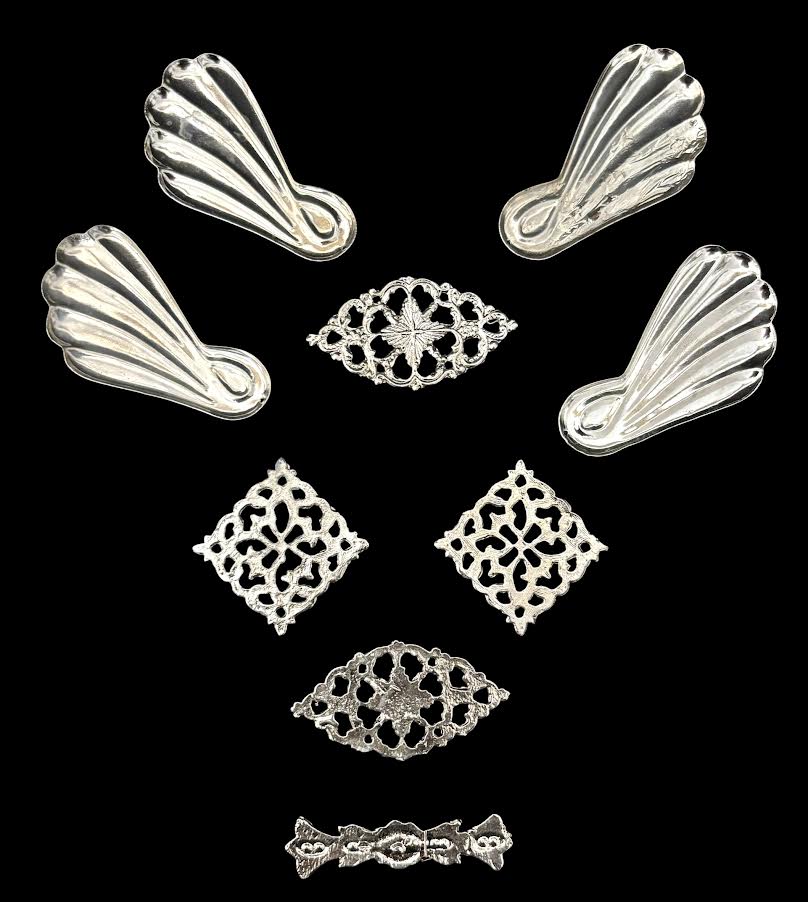 Conjunto de apliques ornamentais em metal prateado, composto por elementos vazados de inspiração clássica e quatro peças em formato de concha. Ricos em detalhes, ideais para restauro de arte sacra ou aplicação ...