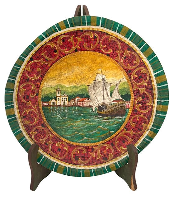 Medalhão decorativo em madeira policromada, com rica ornamentação em relevo e pintura manual. Cena central representando paisagem litorânea com embarcação à vela e arquitetura colonial, cercada por moldura em tons de ...