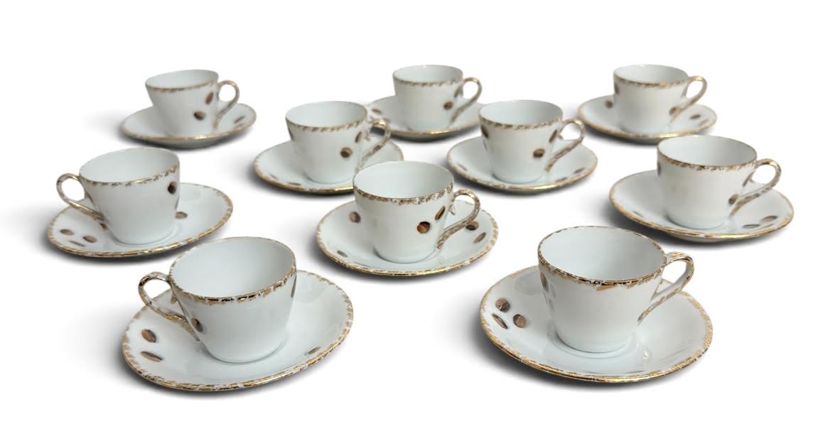 Conjunto com 10 xícaras de café em porcelana Schmidt  Santa Catarina, Brasil, acompanhadas de seus respectivos pires. Decoração delicada com bordas douradas e motivo de grãos, apresentando desgaste natural no dourado ...