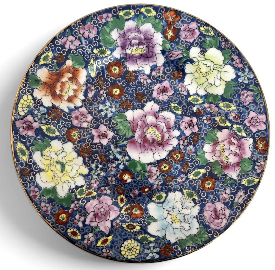 Prato em porcelana oriental estilo Famille Rose, com decoração floral abundante sobre fundo azul intenso, ricamente ornado com arabescos e delicada douração na borda. Verso com marca em vermelho e indicação Made in ...