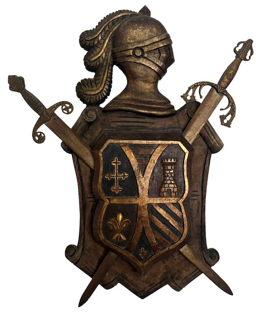 Painel decorativo em madeira entalhada e patinada, representando armadura medieval com elmo, espadas cruzadas e brasão heráldico em relevo. Aplicações em metal/ferro ornamentado, composição de forte caráter decorativo e ...