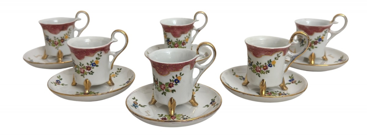 Conjunto com 6 xícaras para café em delicada porcelana europeia, decoradas à mão com motivos florais policromados e ricos detalhes dourados. Peças de formato elegante, destacando pés aplicados em douração e borda em tom ...