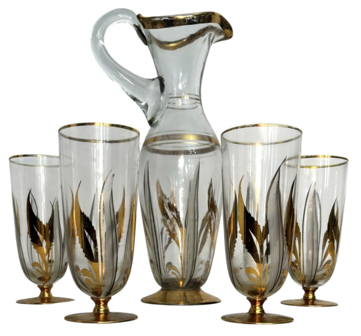 Conjunto em vidro artístico translucido, composto por jarra e quatro copos, decorados com motivos florais estilizados em dourado e negro, com detalhes aplicados à mão e bordas douradas. Peças com elegante influência Art ...