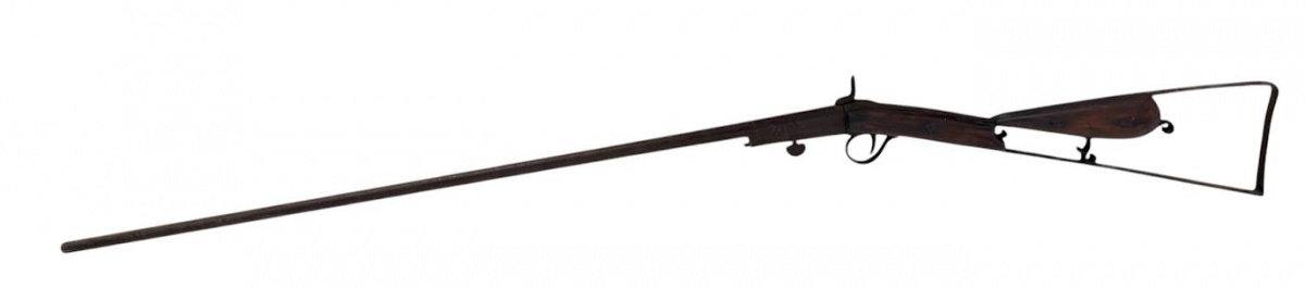 BRASIL SÉC. XIX - Espingarda antiga de caça, provavelmente séc. XIX, de sistema basculante/percussão, com cano longo em metal e coronha em madeira escurecida. Apresenta estrutura de apoio de ombro em armação metálica, ...