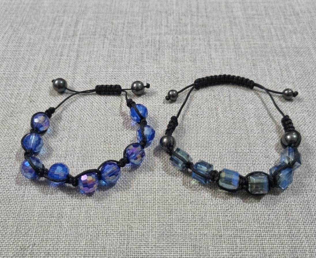 2 PULSEIRAS AJUSTÁVEIS ADORNADAS COM CRISTAIS AZULADOS.