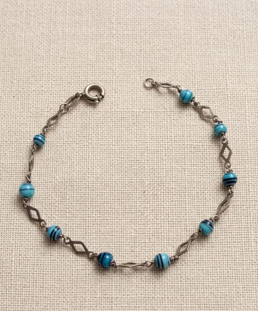 PULSEIRA EM PRATA DE LEI COM ADORNOS NO TOM AZUL, MEDINDO 17CM ABERTA.