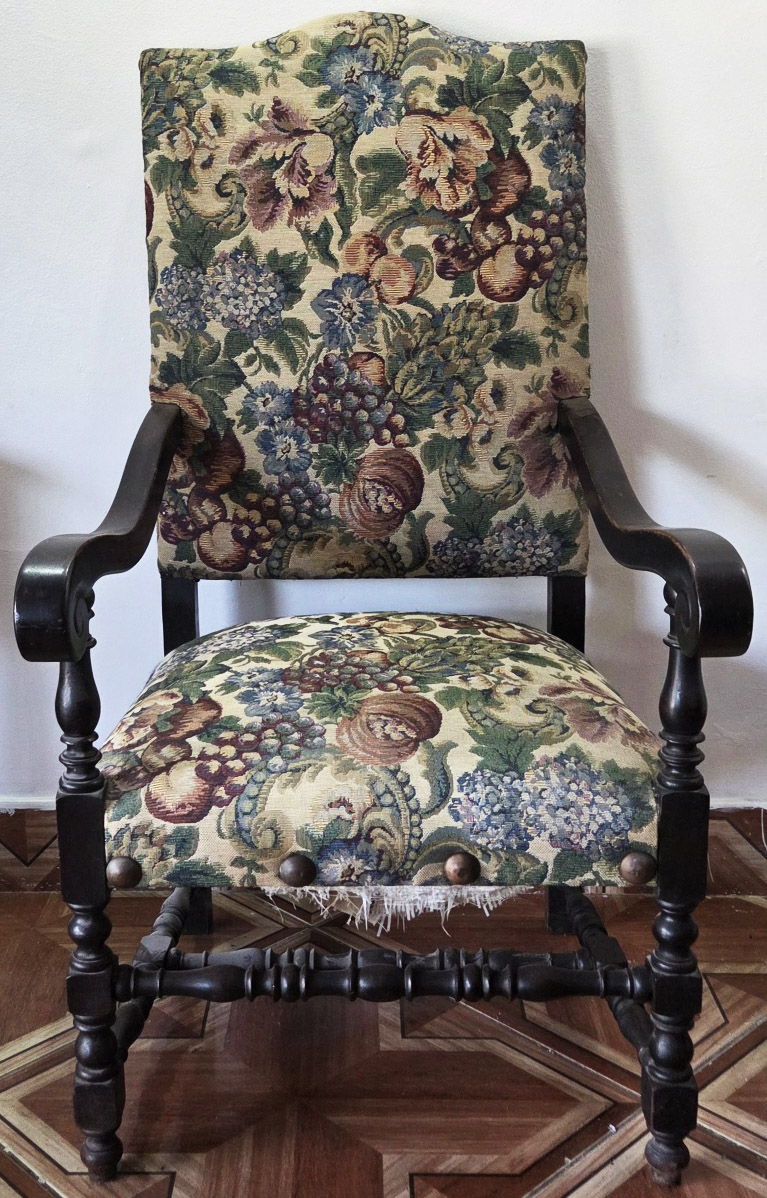 POLTRONA ESTILO Luis XIII em madeira maciça com estofamento floral, pés torneados e travas laterais e central, braços recurvos 125x64x69 cm