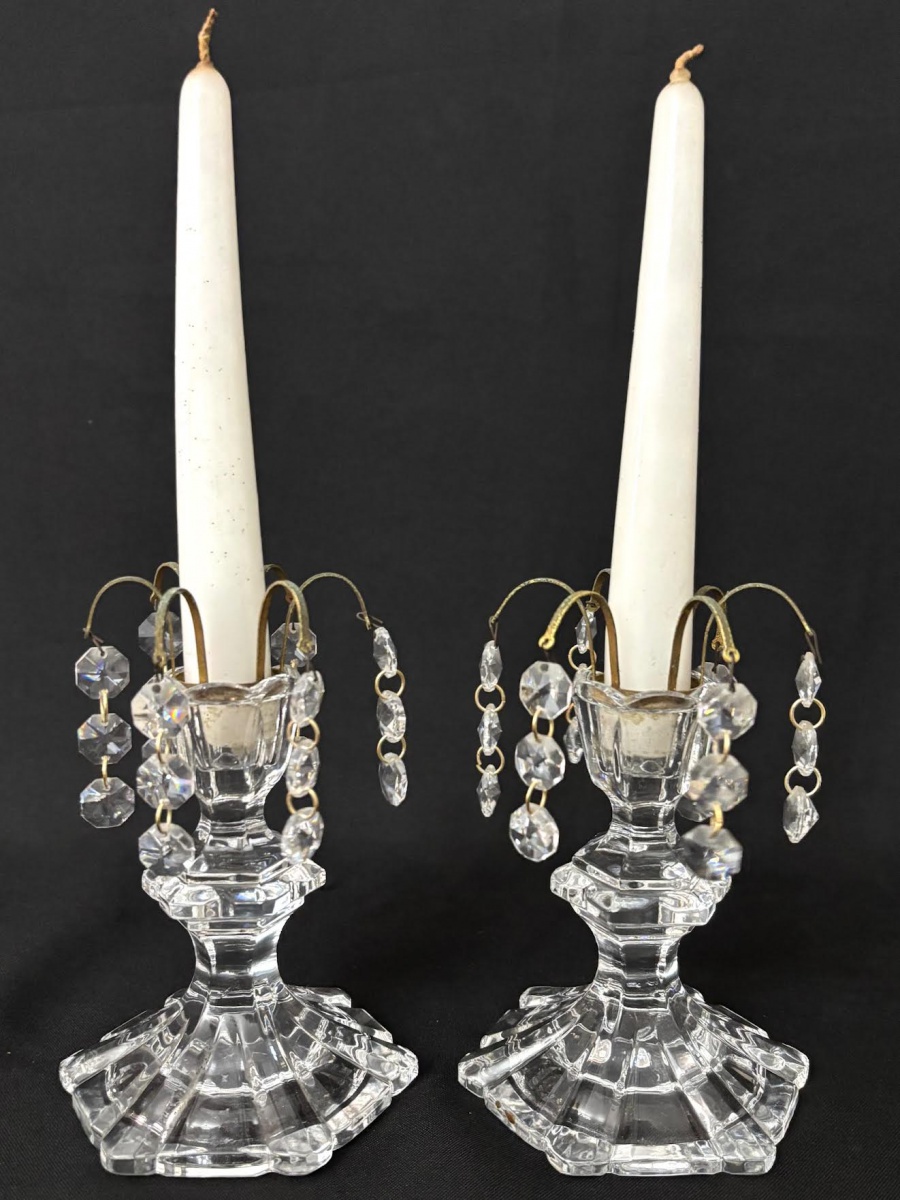 Graciosos castiçais em denso cristal translucido, ornados com ganchos em metal e penduricalhos. Acompanha velas. Mede 15cm.
