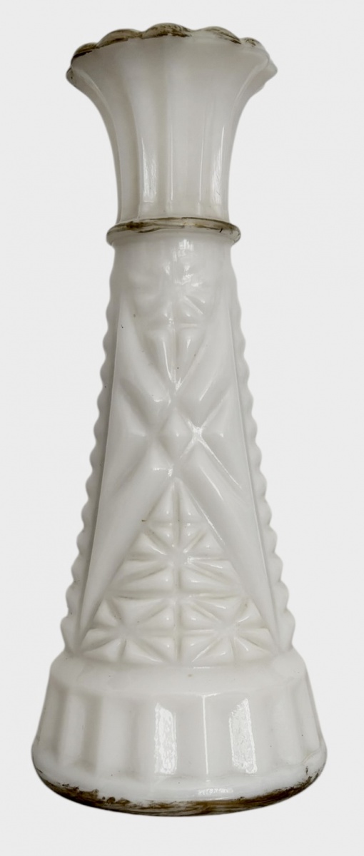 Vaso em vidro opalino branco, corpo facetado com relevo geométrico e motivos florais em moldagem prensada. Boca ondulada em forma de flor e base circular escalonada. Peça de estilo clássico, provável produção europeia ...