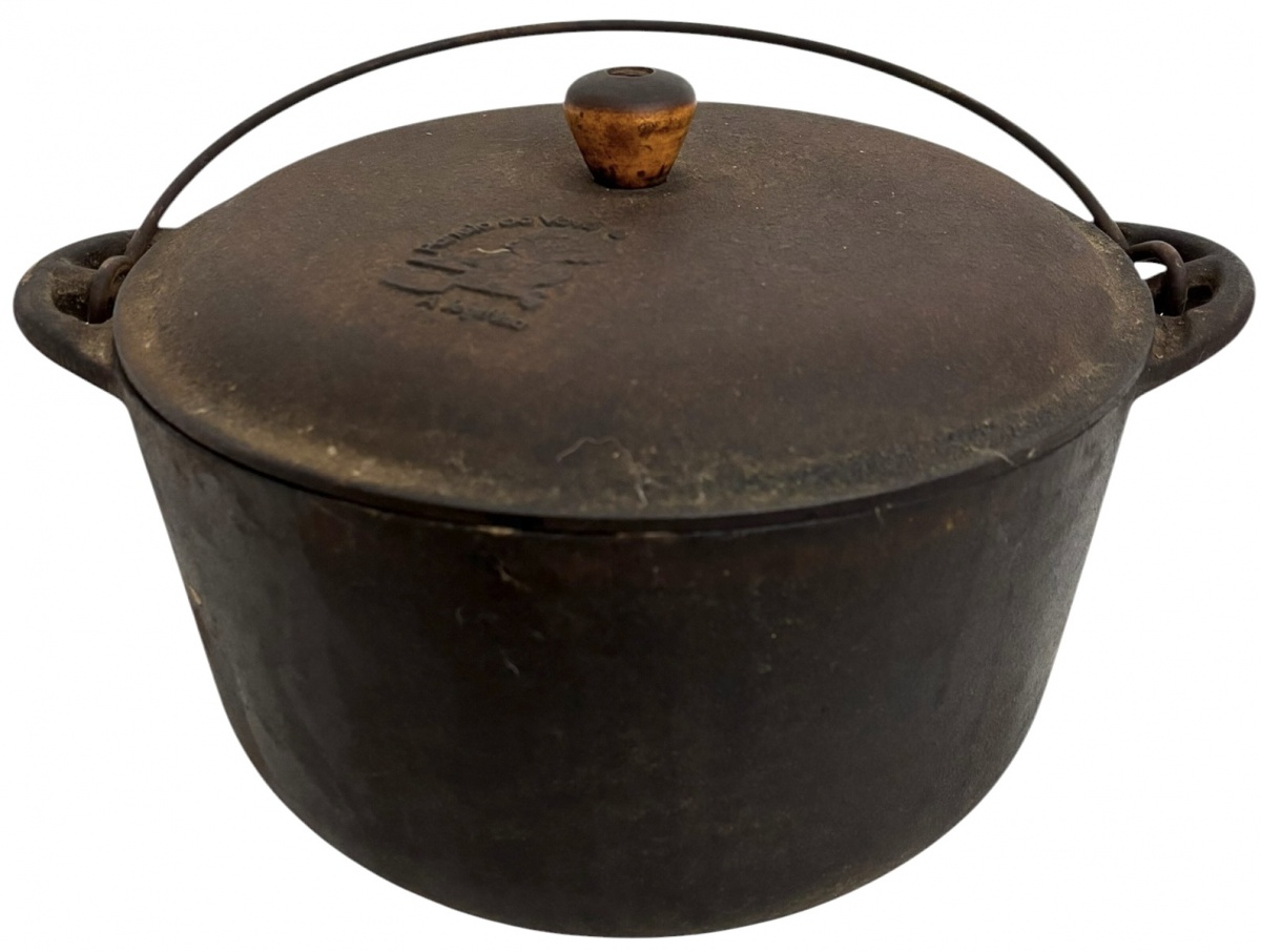 Panela antiga em ferro fundido, com tampa original e alça móvel em metal. Apresenta pegador em madeira e marca em relevo na tampa Panela de Vovó  A legítima. Peça robusta, de uso tradicional, com pátina do tempo que ...