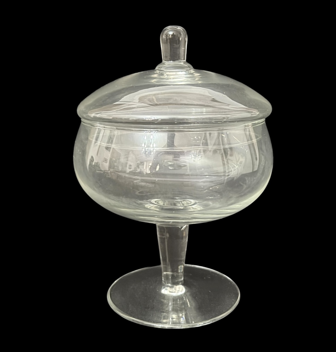 Compoteira com tampa em vidro transparente, apoiada sobre pé circular. Peça de linhas elegantes e formato bojudo, ideal para uso decorativo ou serviço de doces. Em bom estado de conservação. Mede 21 cm.