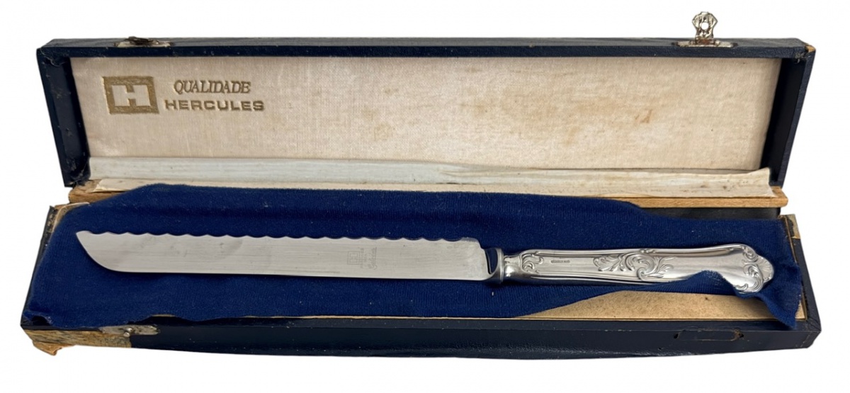 Faca para bolo/torta da tradicional marca Hércules, com lâmina em aço inox e cabo ricamente ornamentado. Acompanha estojo original de apresentação revestido internamente. Peça elegante e funcional, ideal para compor ...