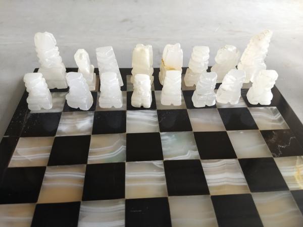 Tabuleiro e peças de mármore para xadrez com peças de b