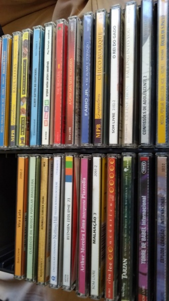 Coleção de 26 CDs variados. Acompanha porta-CDs