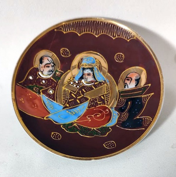 Antigo prato de coleção em fina porcelana japonesa SATSUMA, com decoração representando a Imperatriz e 2 Monges em pintura manual e douração. Está em impecável estado de conservação e mede 10cm de diâmetro.