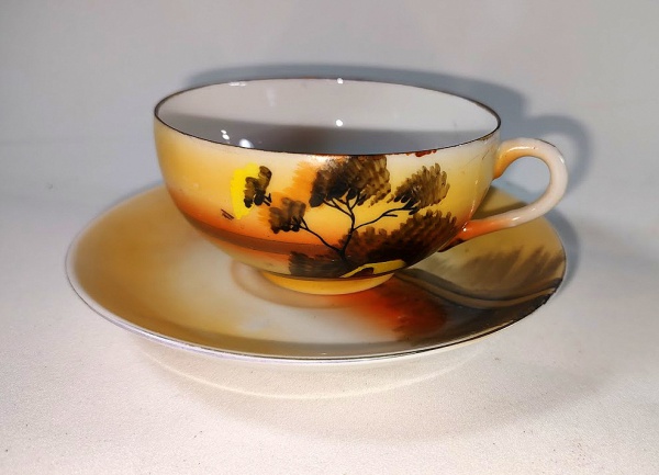Bela Xicara antiga para chá em porcelana japonesa com decoração de paisagem com casa em tonalidades laranjas.