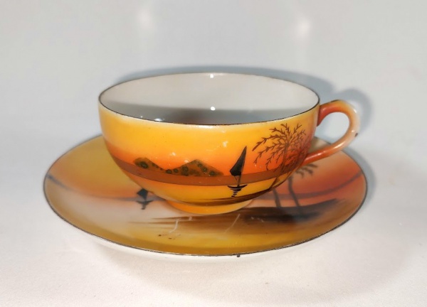 Bela Xicara antiga dos anos 50 para chá em fina  porcelana japonesa com decoração de paisagem litorânea com barco  em tonalidades laranjas. Em impecável estado de conservação