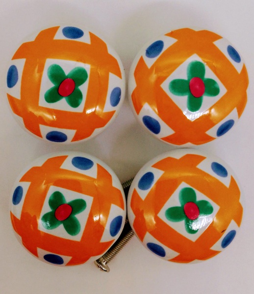 INDIA - Lote contendo 04 (quatro) lindos puxadores de gaveta, confeccionados em porcelana branca com desenhos geométricos nas cores laranja, azul, verde e vermelha. Acompanha ferragens para instalação. Medida: 2,5 cm de altura.  Sem uso.