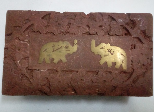 INDIA - Caixa em madeira entalhada, com aplicação de dois elefantes em metal dourado. 12 cm compr, 7 cm larg, 5 cm alt.