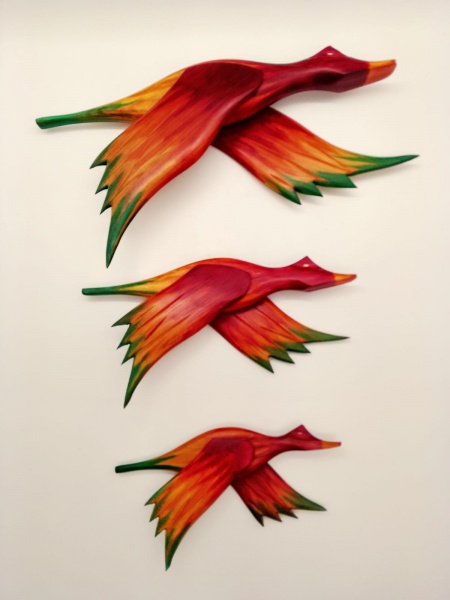 Lote contendo 03 ( três)  patos voadores, confeccionados em madeira nobre,  pintados manualmente na cor predominantemente ocre, com as penas verdes e vermelhas. Medida maior: 32 cm .