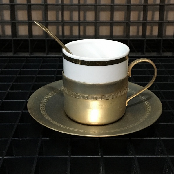 Antiga e delicada xícara de coleção em metal dourado com recipiente em porcelana. Sinais de desgastes. Dimensões: 60 cm.