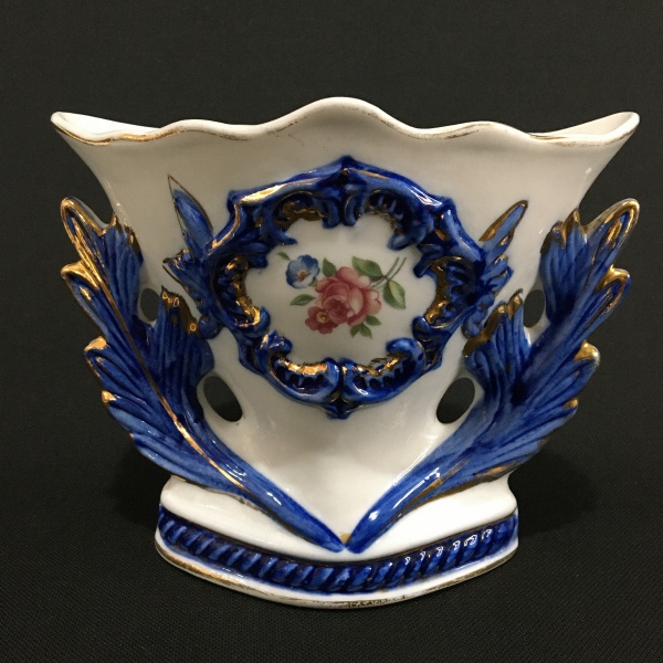 Gracioso vaso floreira em cerâmica esmaltada decorado com folhas de acanto , estilizados na cor azul , arranjos florais e realces pintados a ouro. Dimensões:14 cm x 17 cm x 7 cm .