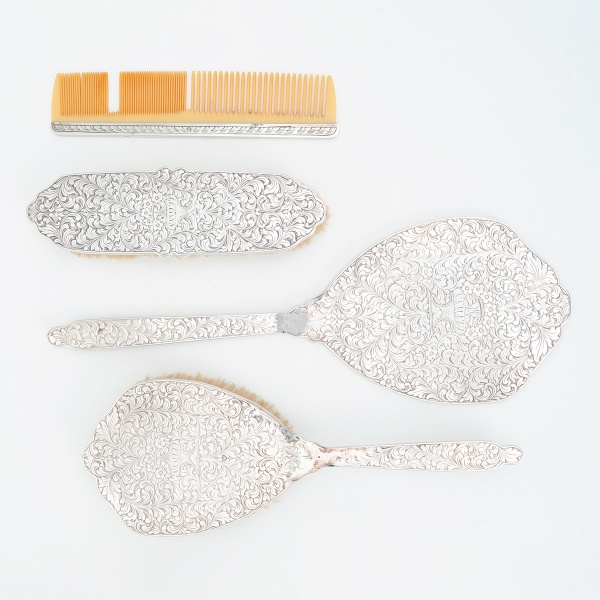 Antigo conjunto de toucador em prata, constando: 1 escova de cabelo, 1 escova de roupa, 1 espelho e 1 pente. Peso total: 568 gramas. Comprimento: 22 cm.