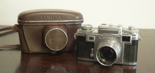 Máquina fotográfica analógica `CONTAX`, lente Zeiss Optom Sonnar 50mm, com estojo.  Material estava guardado, estamos vendendo no estado em que se encontra.