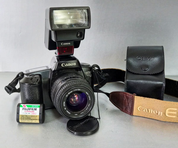 Câmera fotográfica Canon EOS 1000 QD, 35-80mm, 1:4- 5.6, Sigma. Auto focus, 1063610. Câmera não funcionando, mas o flash externo funciona. Flash da Canon Speedlite 300 EZ, Inclui bolsinha para o flash. Comprimento da câmera com a lente: 12.5 cm, Comprimento da lente: 7.5 cm, Largura da câmera: 15 cm, Altura do flash: 9 cm, Peso total: 1.080 kg.