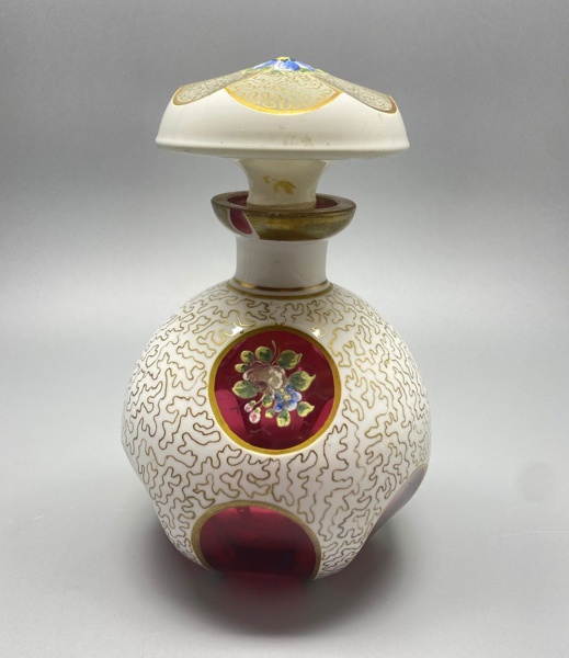 CRISTAL - Belo perfumeiro em cristal overlay, branco e rubi, pintado a mão com flores policromadas, ricos em detalhes dourados, lapidação dedão. Alt. 15 cm. Bicado externo no bocal.