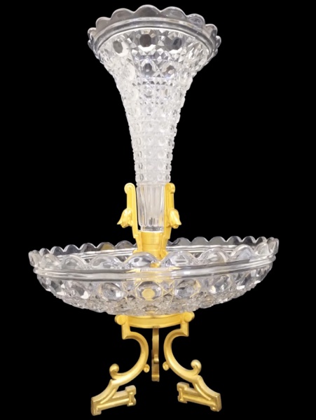 BACCARAT - Imponente fruteira em cristal francês completamente lapidado com com 2 platôs sobre tripé de bronze dourado com bordas onduladas; medindo 40 x 25 cm, contém a marca da manufatura.
