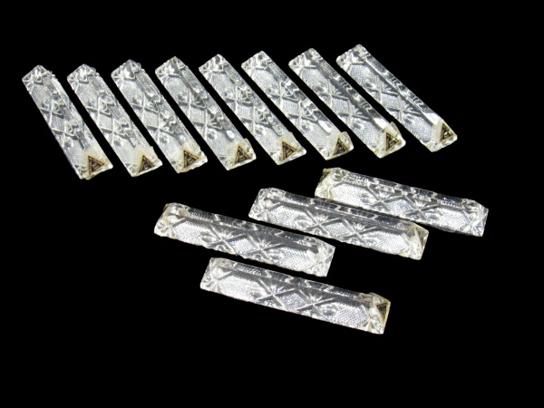 CRISTAIS, Doze descansa talheres confeccionados em cristal translucido lapidado por palmas, losangos e pingos de diamante em baixo relevo, medindo 9 cm de comprimento, acondicionados em caixa original.
