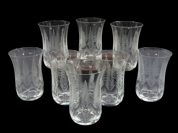 CRISTAIS, Oito copos para água confeccionadas em cristal translucido com lapidação de folhagens, esferas e sulcos em baixo relevo, 2 apresentam bicado, medindo 13x8,5cm.