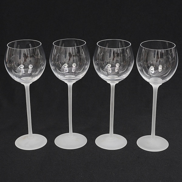 Conjunto de taças de pé alto, para vinho branco, em cristal francês, diáfano e incolor; fuste longo sobre base circular, ambos executados em vidro acetinado. Composto de quatro(04) unidades. Med.: Alt. 22 x Diam. 8,5 cm.
