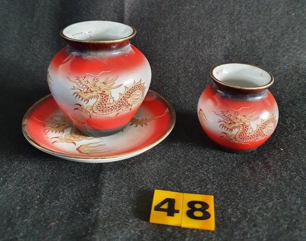 Antigo par de mini vasos com prato em porcelana com assinatura na base. Desenho de dragão. Provavelmente da década de 70. Medidas dos vasos: 7cm X 6,5cm e 5cm X 5cm. Medida do pires: 11cm de diâmetro.