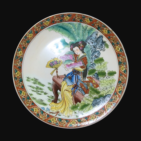 CHINA - Belo prato em porcelana esmaltada decorado com figura feminina ao centro e ladeada com arabescos e flores. Diemsões : 26 cm .