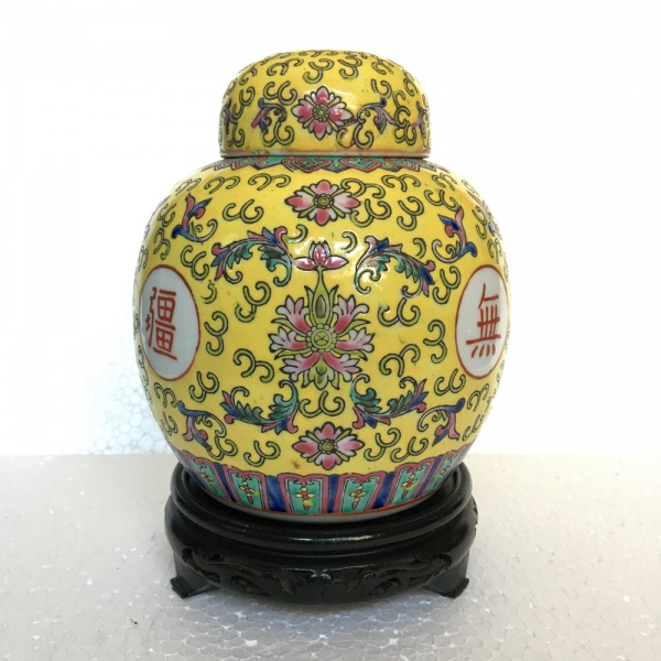 CHINA - Belo potiche em porcelana esmaltada decorado com arabescos e elementos vegetalistas sobre fundo amarelo. Acompanha penhanha em madeira. Dimensões: 18 cm x 12 cm.