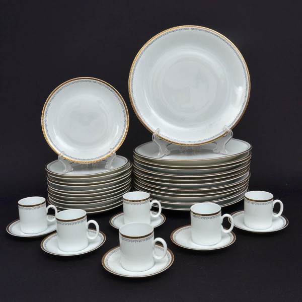 MEDAILLON - PORCELANA RENNER - Conjunto de 12 pratos rasos em porcelana nacional  e 12 pratos de sobremesa medindo 18 cm. Possui decoração dourada em sua borda, acompanha seis xícaras de café com pires.